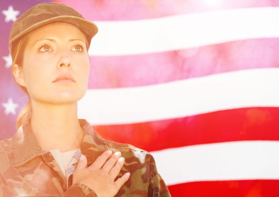 Digital composite of veterans day soldier in front of flag