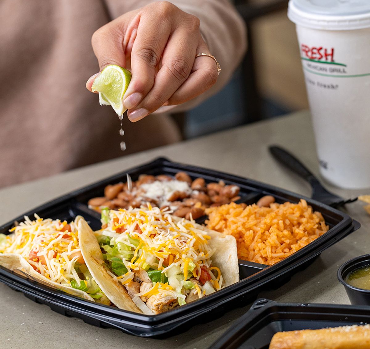 Squeezing a lime over a taco plate