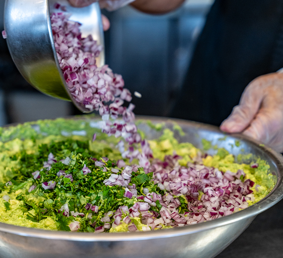 Making guacamole in a large mixing bowl