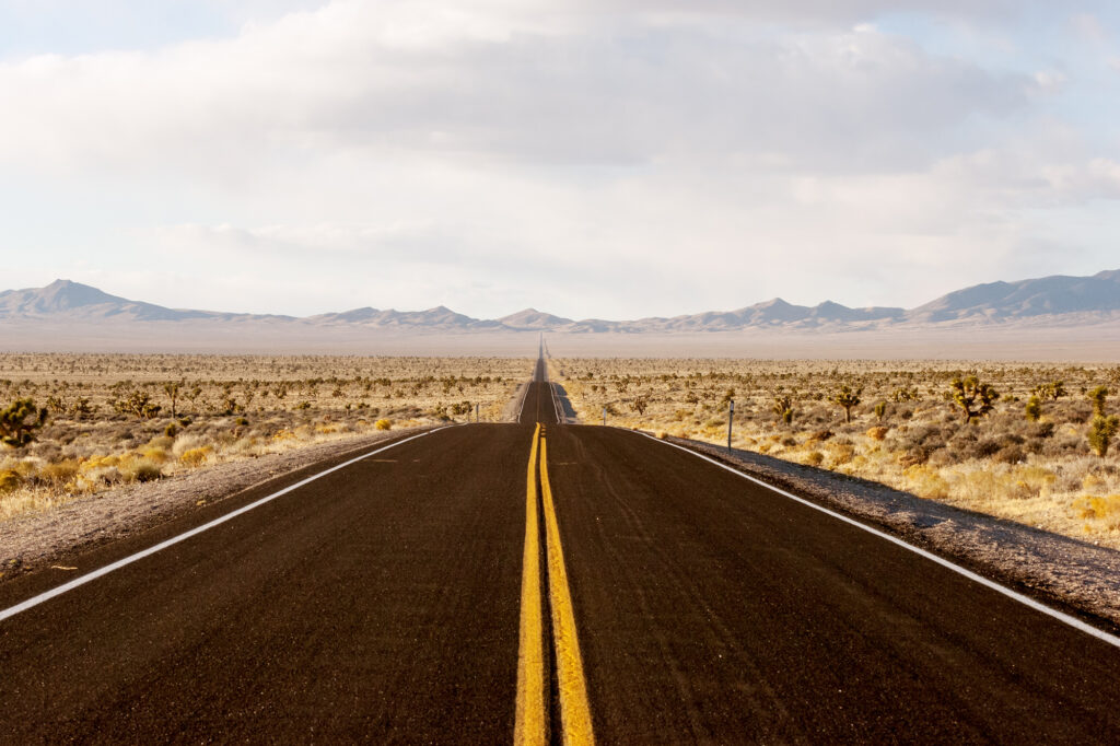 Long open highway through the desert symbolizing the long-term journey and investment required when building a franchise business.