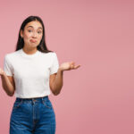 Woman shrugging with questioning expression representing evaluating important questions before buying a franchise.